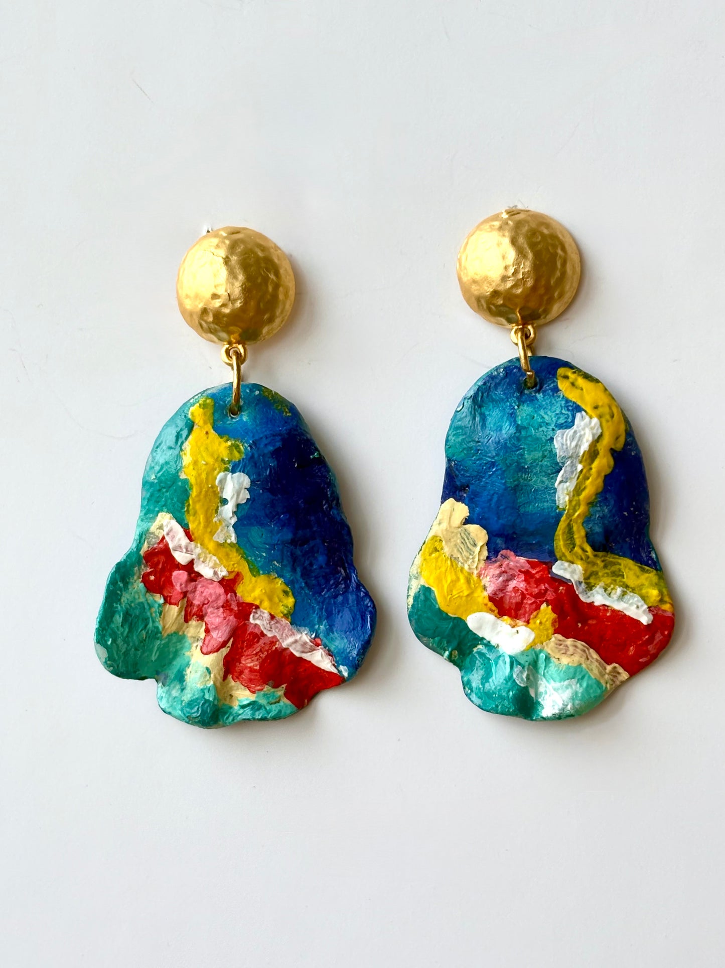 Handmade and hand-painted colorful abstract drop earrings with hammered gold studs on a white background
