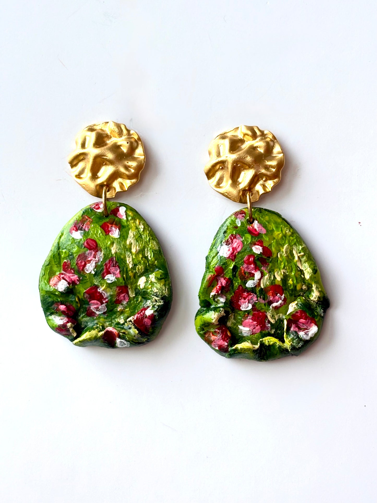 Handmade and hand-painted green floral drop earrings designed in Brussels by Ozlem Cali on a white background